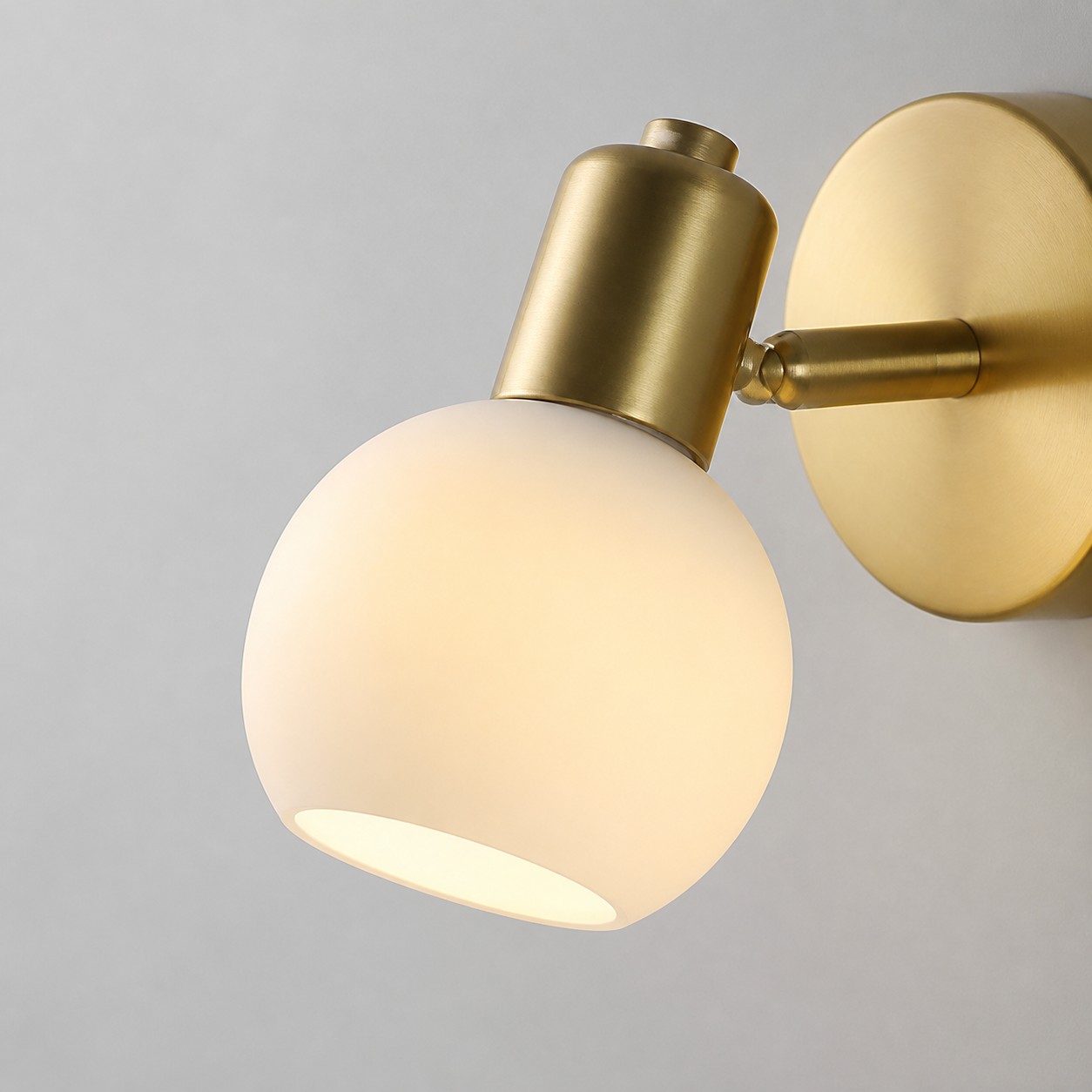 Nahaufnahme einer goldenen Wandleuchte mit Glasschirm