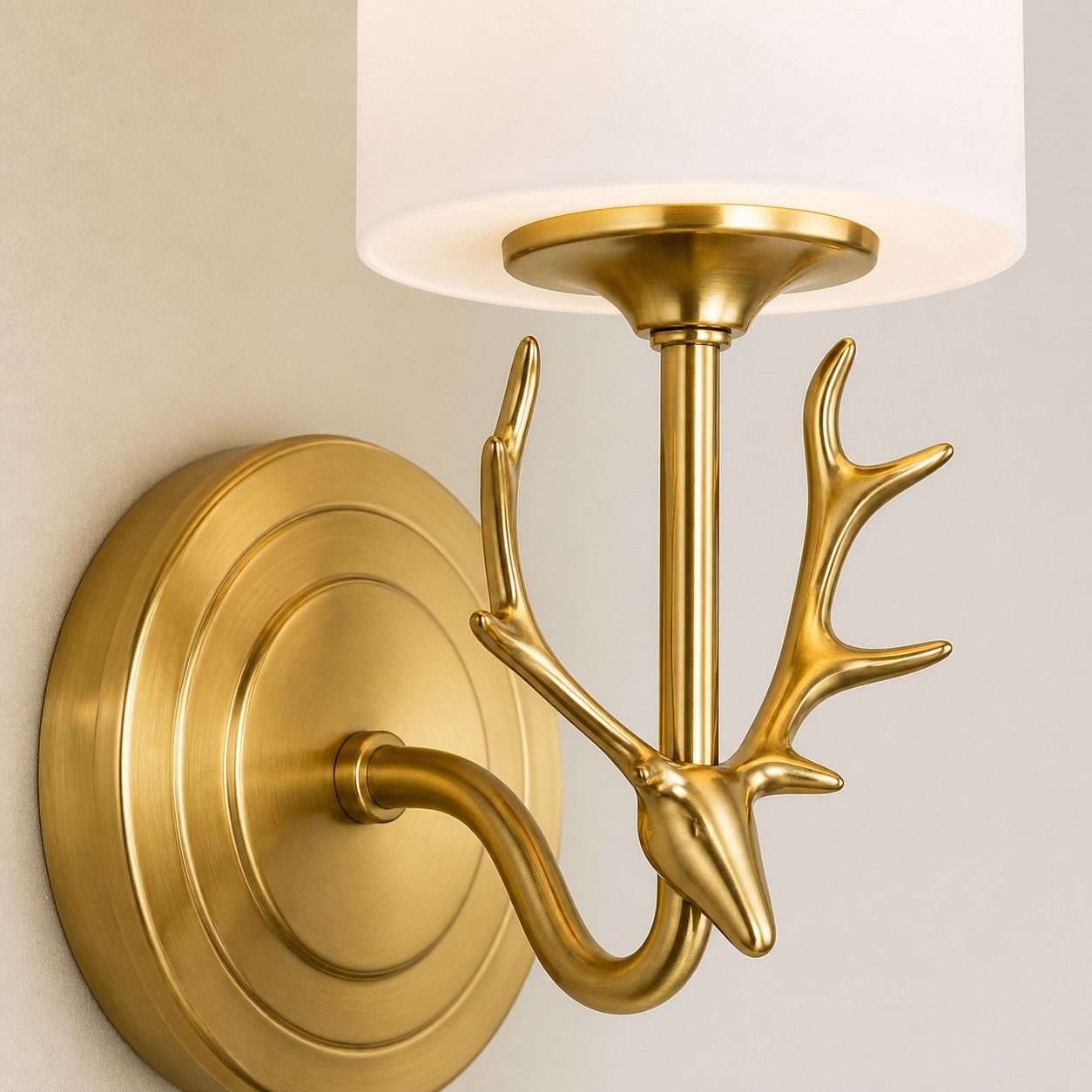 Close-up of brass antler wall sconce with white glass shade