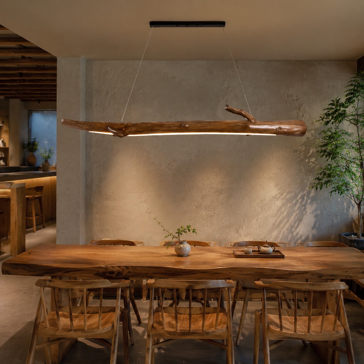 Lámpara colgante inspirada en una rama sobre una mesa de comedor larga.
