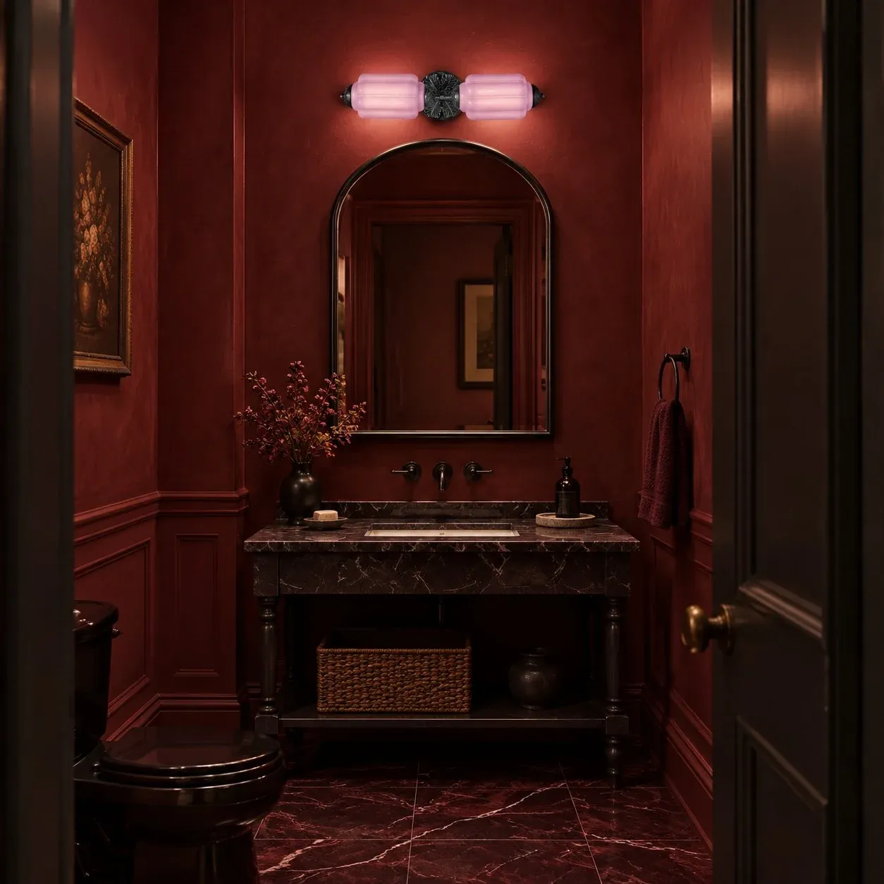 Pink and black vanity light in a burgundy bathroom