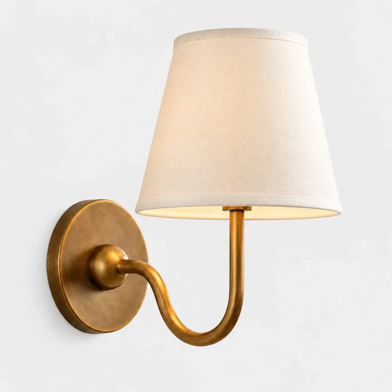 One-head brass wall sconce with a beige fabric shade