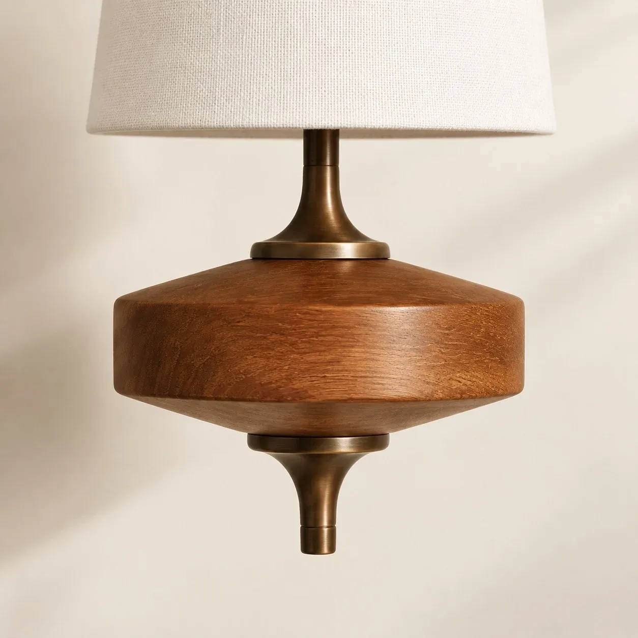 Antique brass neck joining the fabric shade to the walnut base