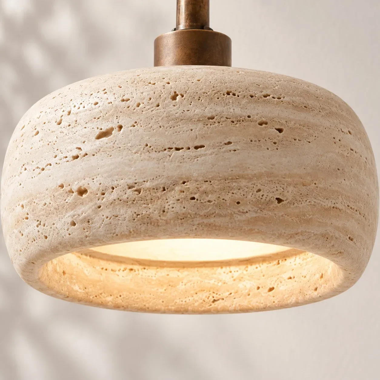 Close view of a rounded travertine shade with open bottom