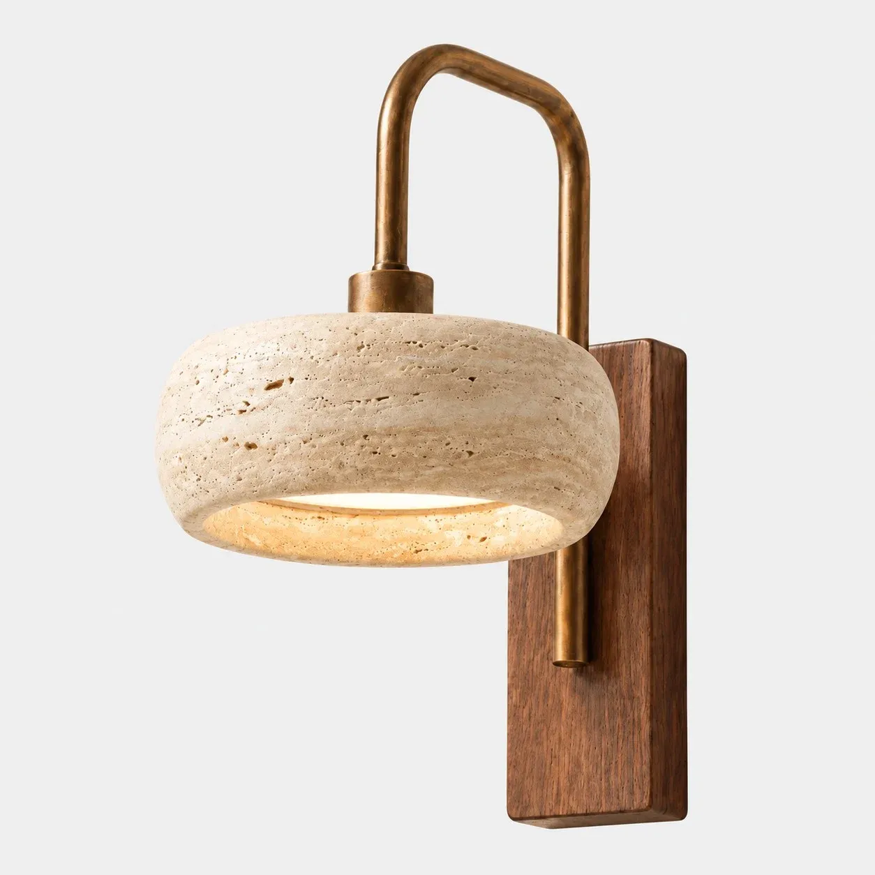 Rounded travertine cylinder wall sconce with a brass arm and walnut backplate