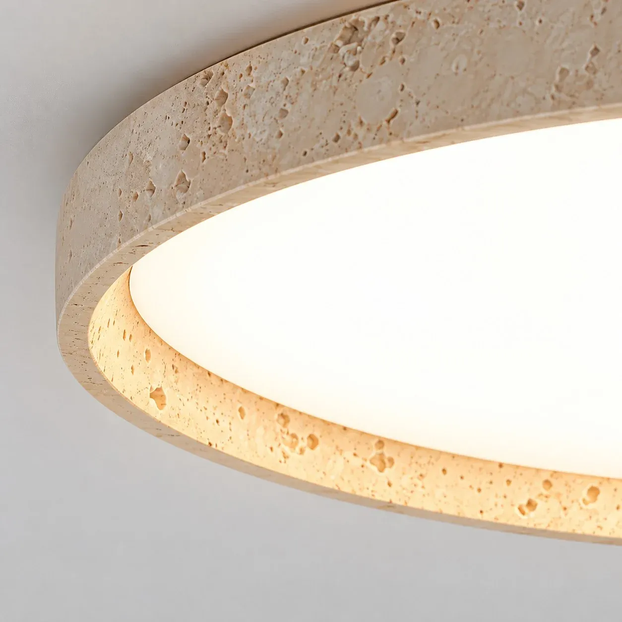 Round acrylic diffuser inside a travertine ring, with a warm inner edge