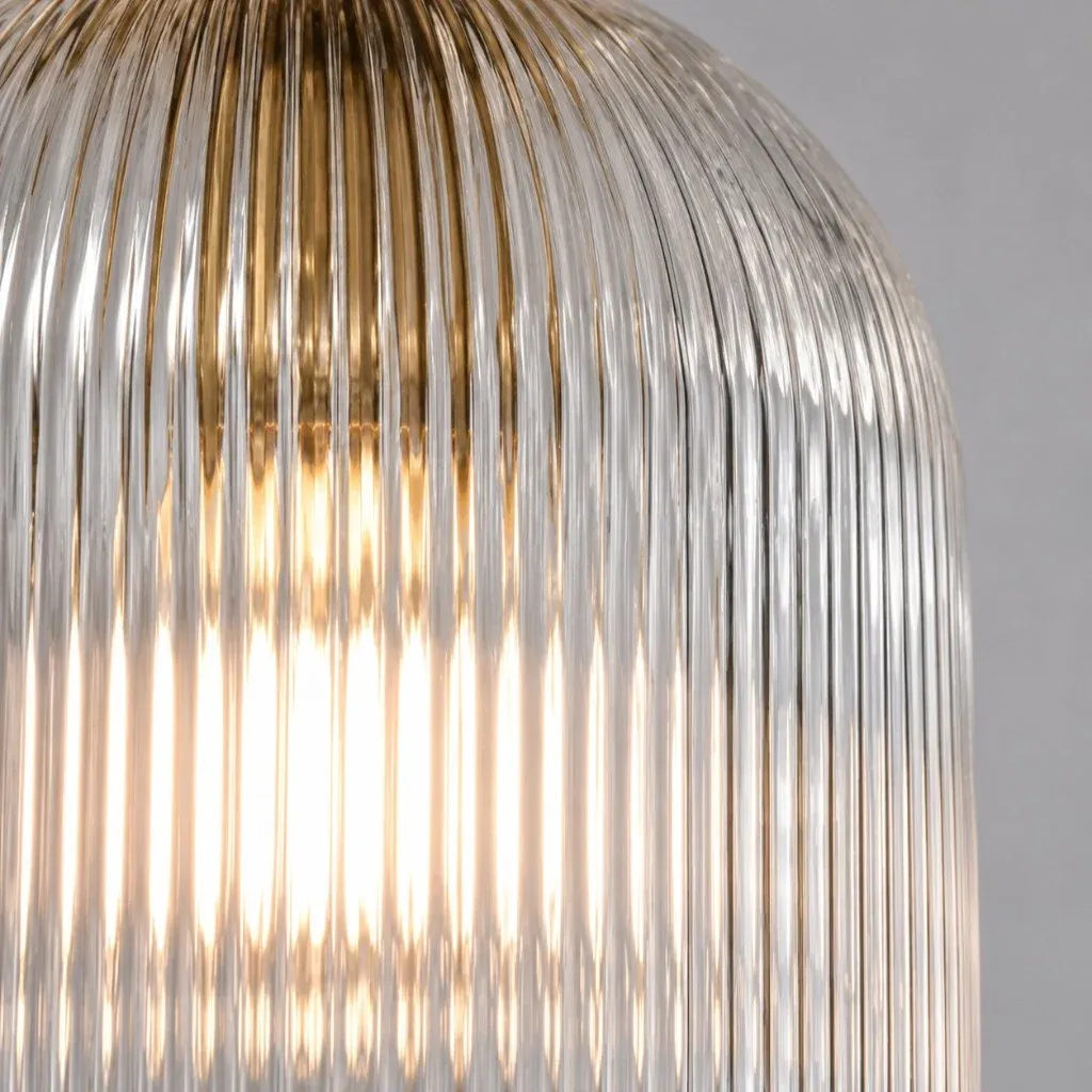 Close view of vertical ribs in a clear glass shade with a brass interior