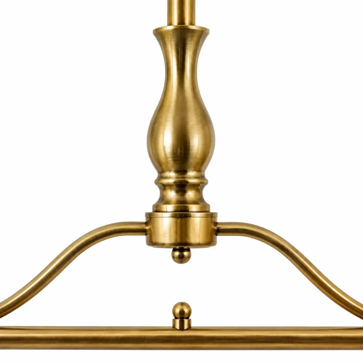 Close view of the turned brass urn, curved arch, and the sphere on the straight bar
