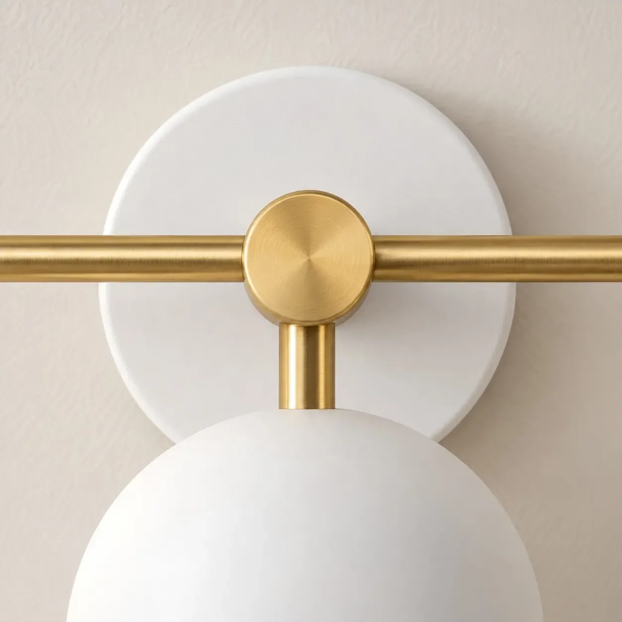 Brushed brass center joint where the bar meets the stem, in front of a white canopy