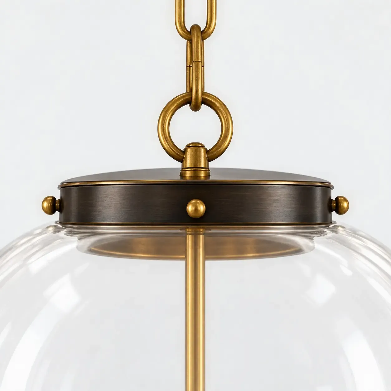 Dark metal collar with brass knobs, a brass ring, and a brass chain on the glass globe