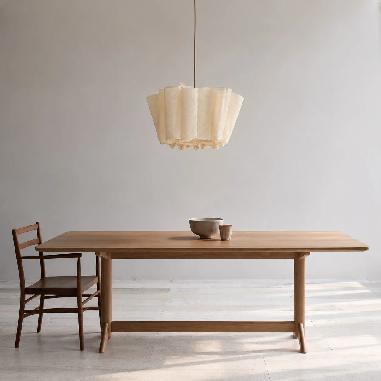 Pleated linen pendant over a long wood table