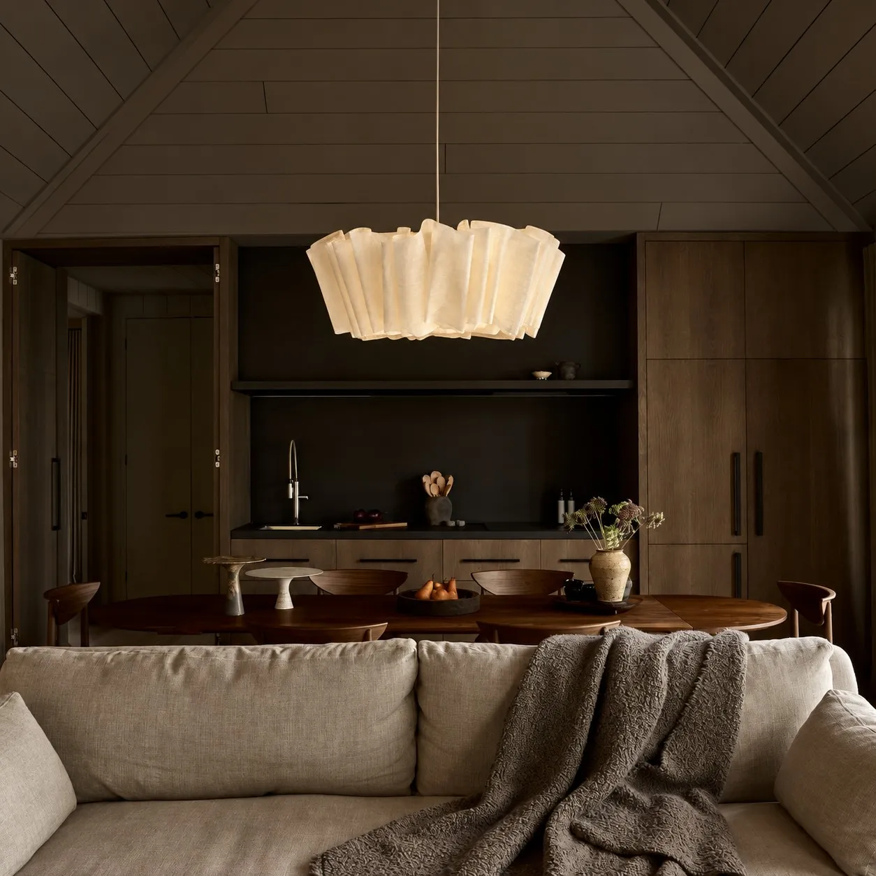 Pleated linen pendant in a dark dining room
