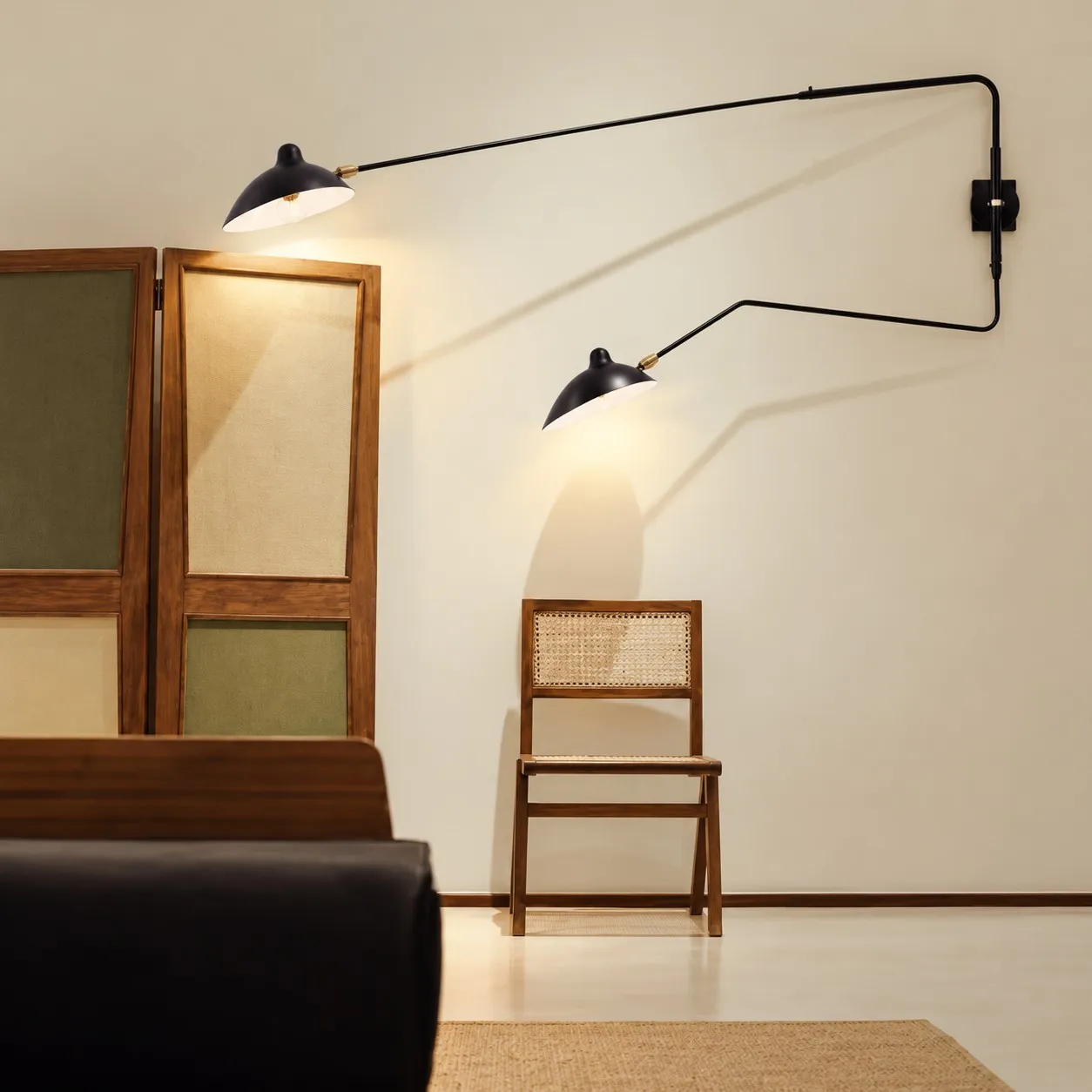 Black two-light wall sconce beside a wooden chair