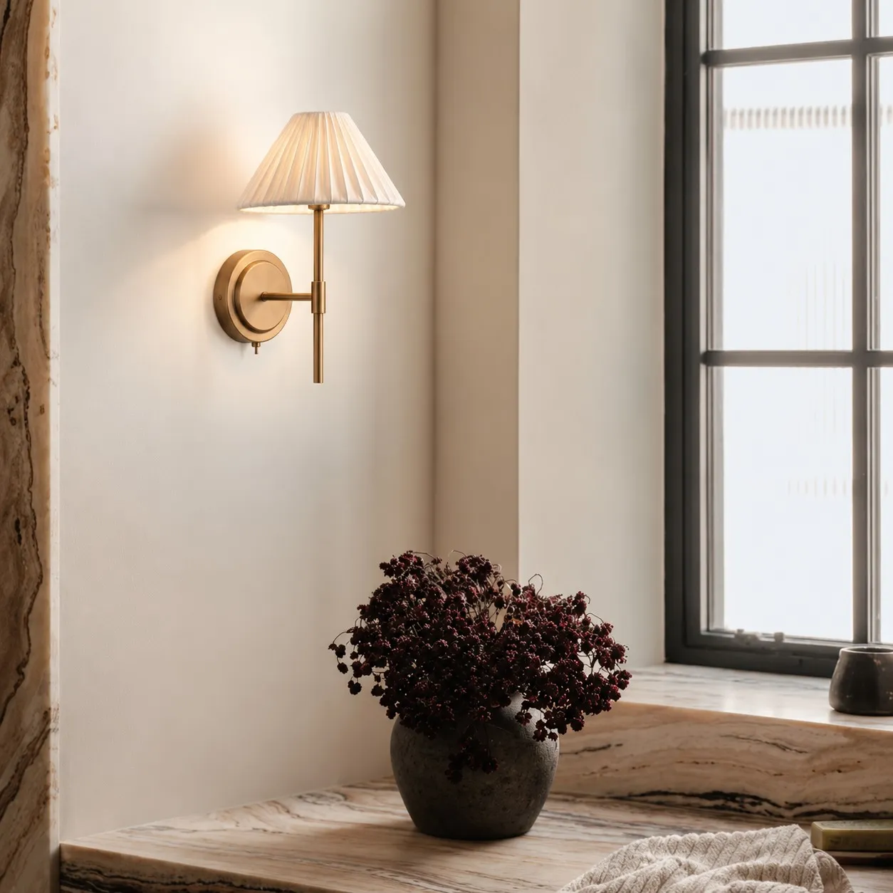 Pleated linen wall light beside a window