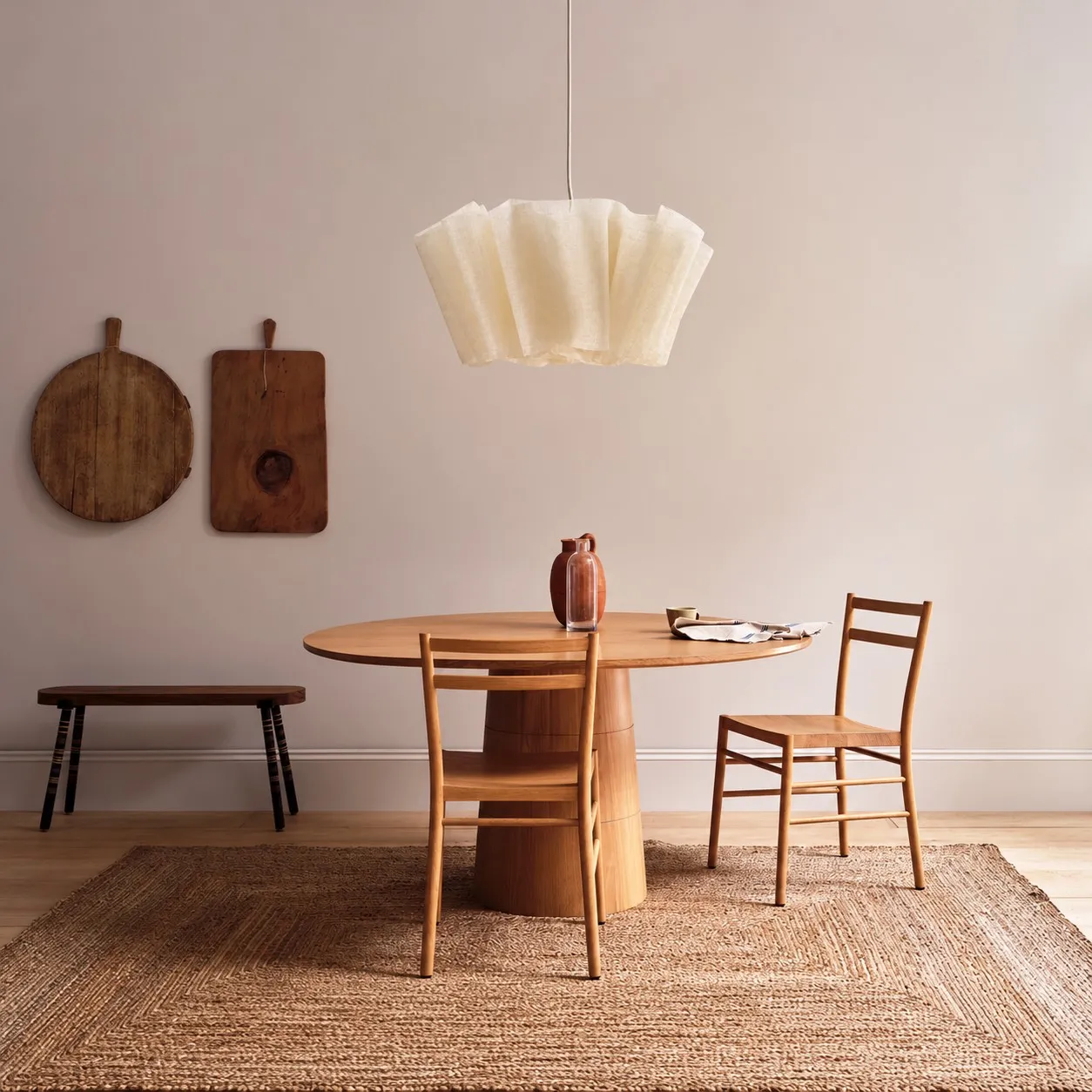 Pleated linen pendant over a wood pedestal table