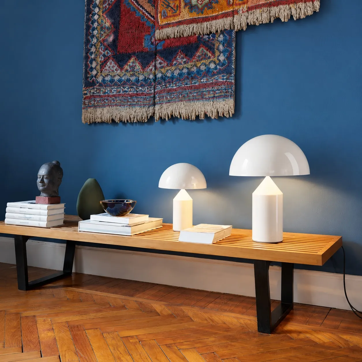 Two glossy white mushroom table lamps on a wood bench