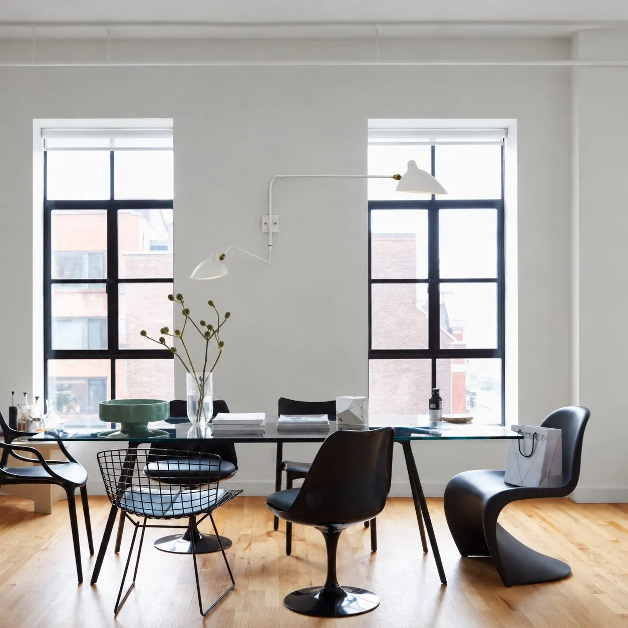 White two-light wall sconce above a dining table