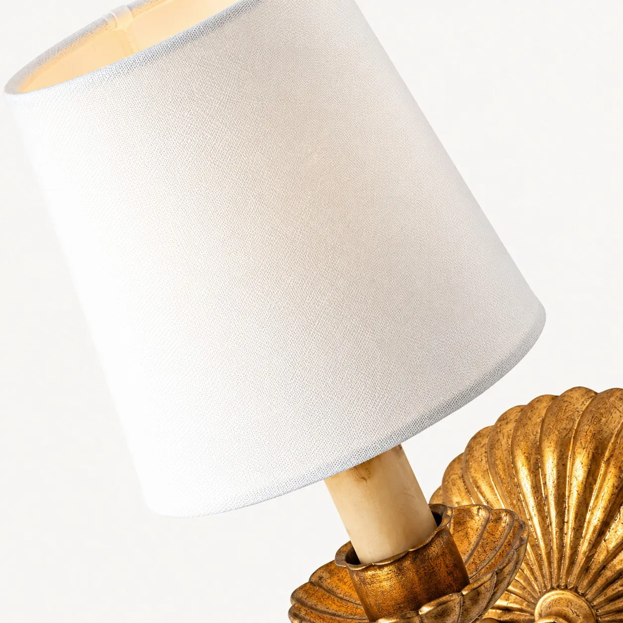 White fabric shade above a fluted gold cup